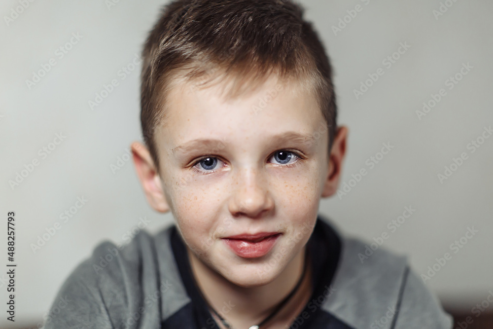 close-up portrait of serious caucasian boy with freckles in casual wear close-up portrait of serious caucasian boy with freckles in casual wear