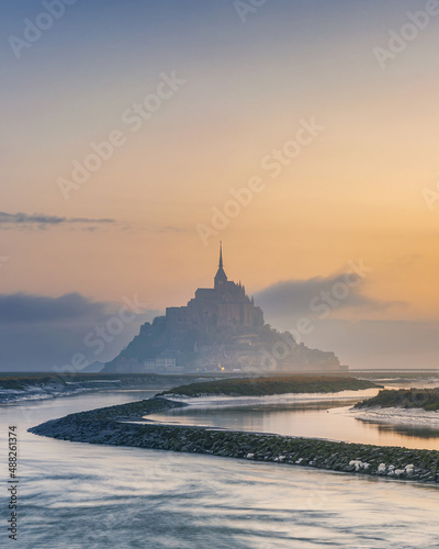 Moody sunrise at Le Mont Saint Michel abbey on the island in foggy morning, Normandy, Northern France, Europe