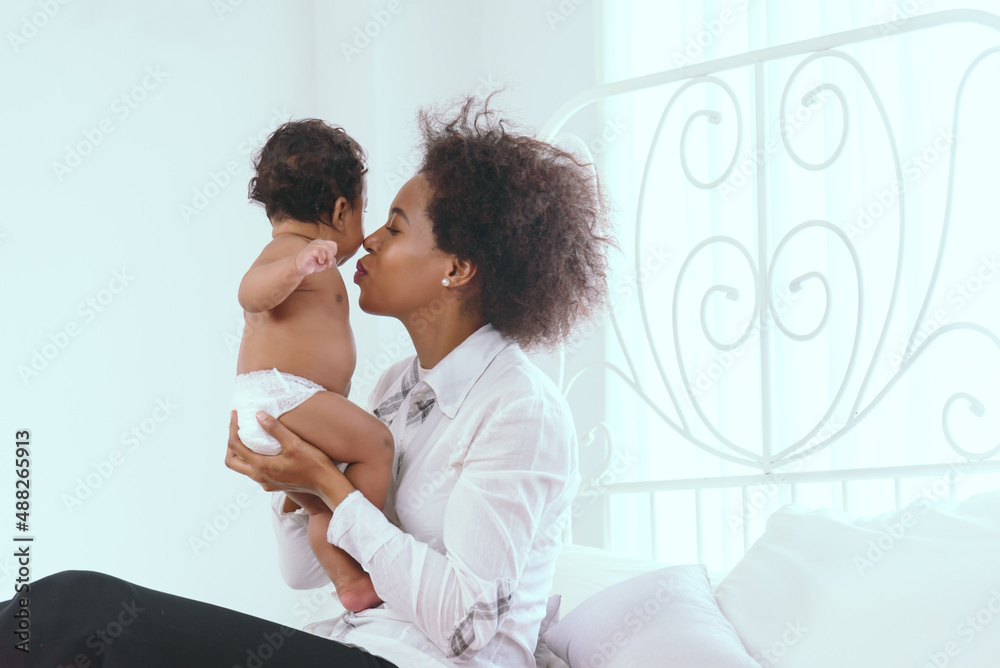 Black mother is having fun in her bedroom in the house. Black mother is having fun in her bedroom in the house.