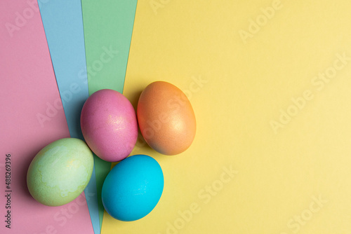 four painted eggs lie on colored backgrounds
