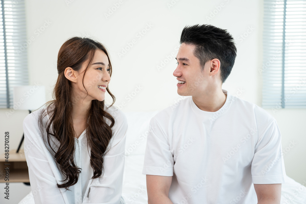 Portrait of Asian new marriage couple sit on bed and look each other. Portrait of Asian new marriage couple sit on bed and look each other.