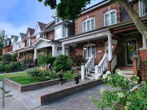 Photography Urban residential street with row of older semi-detached houses with front garde