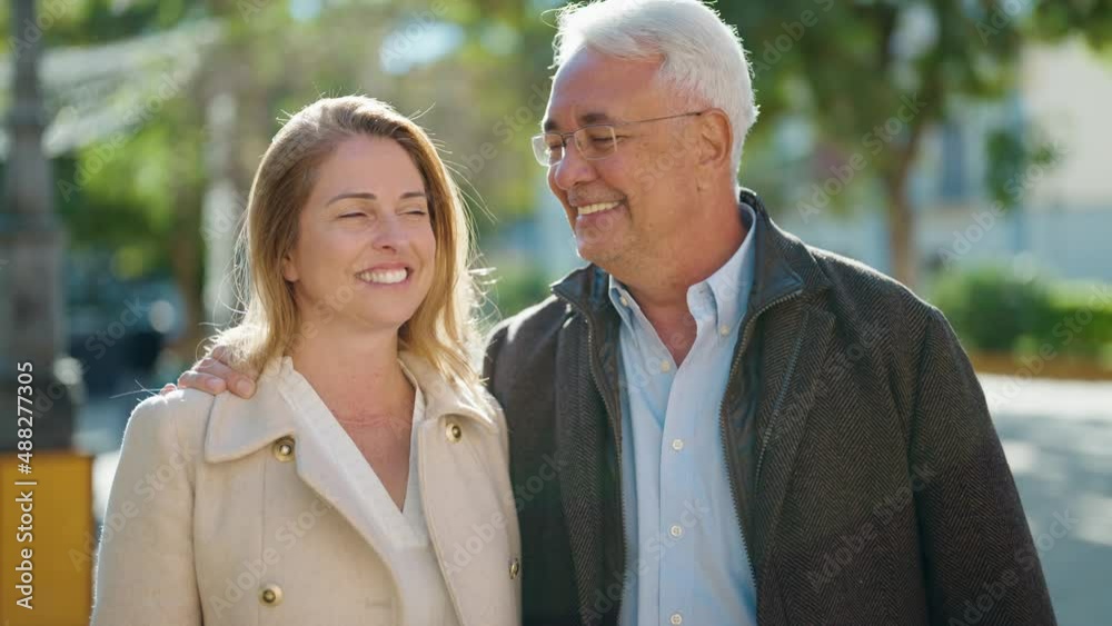 Middle age couple couple smiling confident hugging each other at park