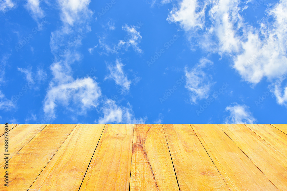 Blue sky and white clouds for background. green lawn foreground, wooden floor foreground.