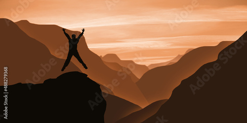 Mountain success Concept. Happy young  man Jumping on the top of maintain at sunset time. Panoramic mountains landscape and businessman challenge  © MedRocky