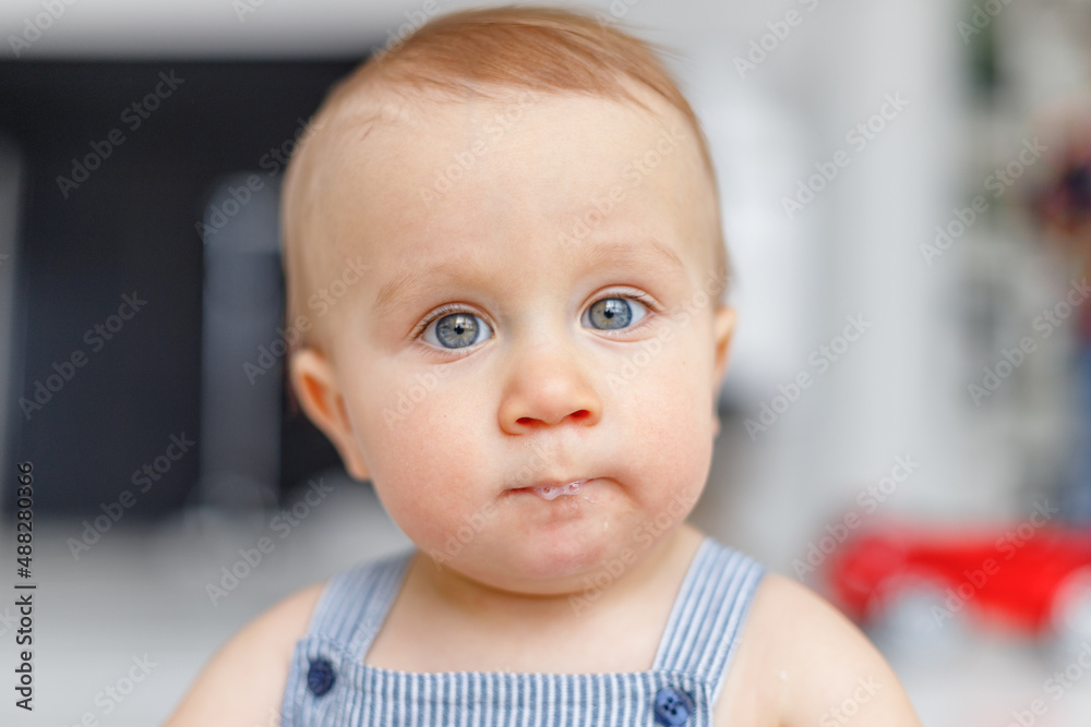 Portrait of a baby with blue eyes on a light background, white background for advertising