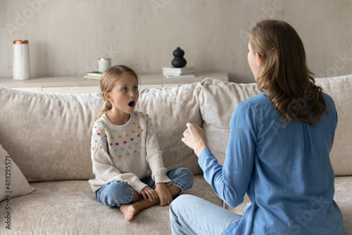 Singing teacher training student girl kid at home. Speech therapist teaching child to do voice, speaking exercises, helping to cope stutter, bad pronunciation, communication problems photo