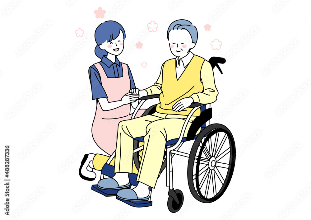 車椅子に乗るシニアと手を握る介護士