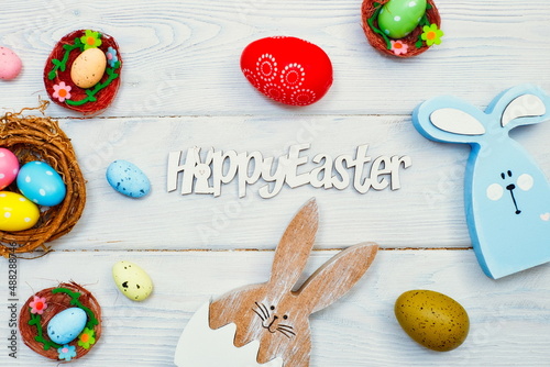 Coloeful easter eggs in nest on wood  background with space. Minimal concept. Card with copy space for text. photo