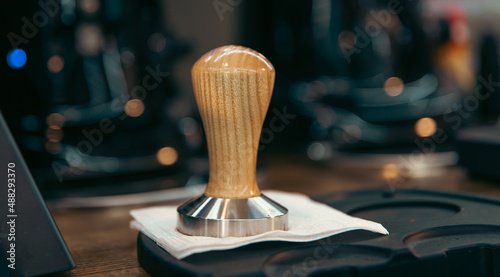 Close-up of a coffee tamper on a blurred background. photo