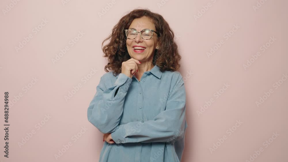 Middle age woman smiling confident standing over pink background Middle age woman smiling confident standing over pink background