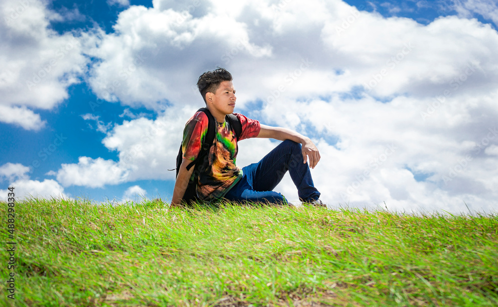 A guy sitting on a hill enjoying the scenery, tourist sitting on a hill enjoying the scenery A guy sitting on a hill enjoying the scenery, tourist sitting on a hill enjoying the scenery
