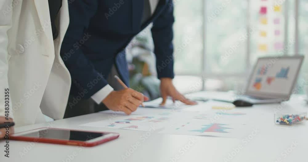 Two businesswomen analyzing graphs in an office Two businesswomen analyzing graphs in an office