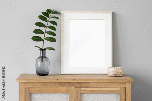 Fototapeta Naklejka Na Ścianę i Meble -  Blank picture frame mockup on white wall. Template for painting or poster. White living room interior design. View of modern rustic style interior with artwork mock-up