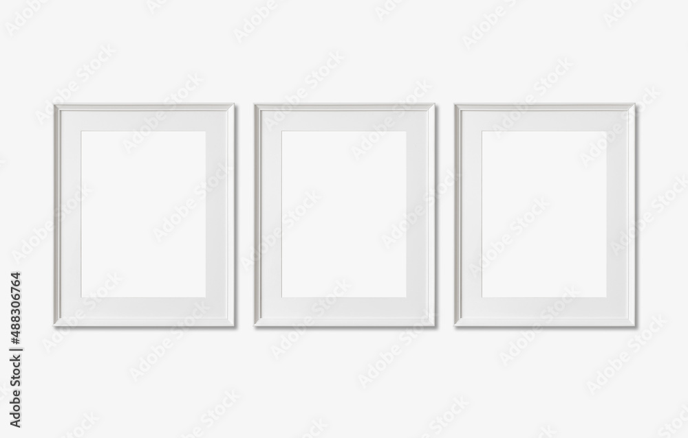 Picture frame mockup. Set of three vertical white frames on white wall background. Empty, blank template for artwork, painting or poster. Picture frame mockup. Set of three vertical white frames on white wall background. Empty, blank template for artwork, painting or poster.