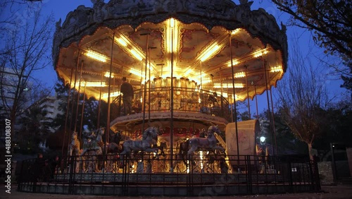 Illuminated carousel at night in an amusement park slow motion 4k
