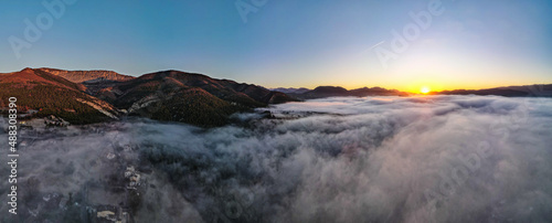 Aerial panoramic view of sunrise above the clouds in the Mountains of the Alps