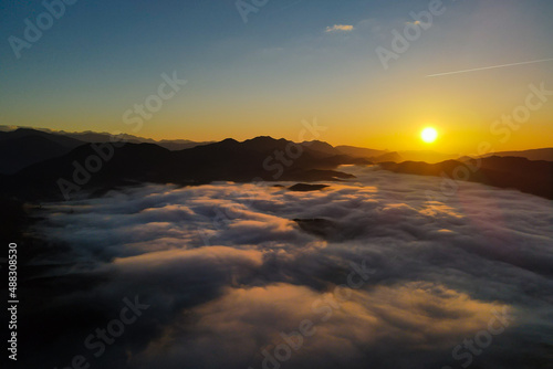 Aerial panoramic view of sunrise above the clouds in the Mountains of the Alps