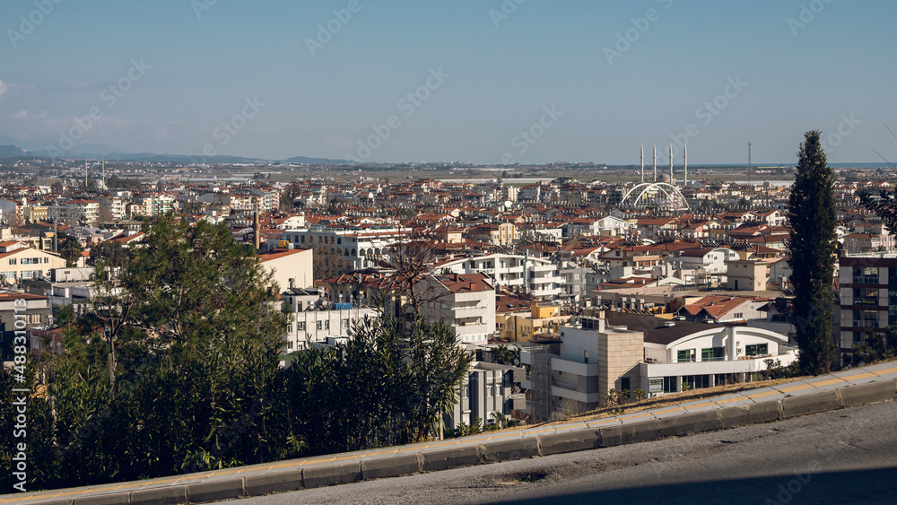 Obraz premium Residential area in a tropical country with many similar houses with water barrels basking in the sun, mountain at the background , soft focus