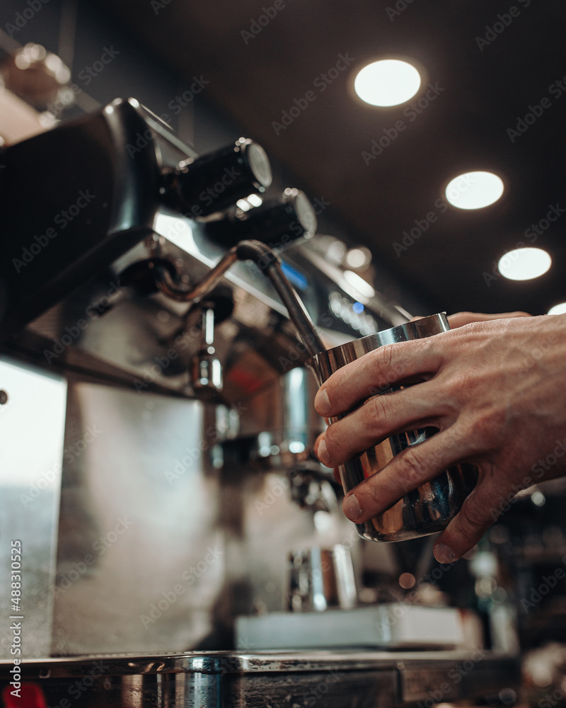 Details of a modern chrome coffee machine in the dim light of a coffee shop - professional barista equipment