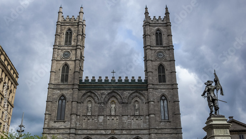 Architectural detail of the Place d'Armes in Montreal, Canada, with the Notre-Dame Basilica in the background and in the foreground the monument of Paul de Chomedey, founder of the city