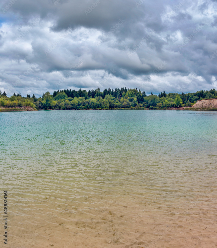 lake in the limestone quarry on a cloudy gloomy summer day