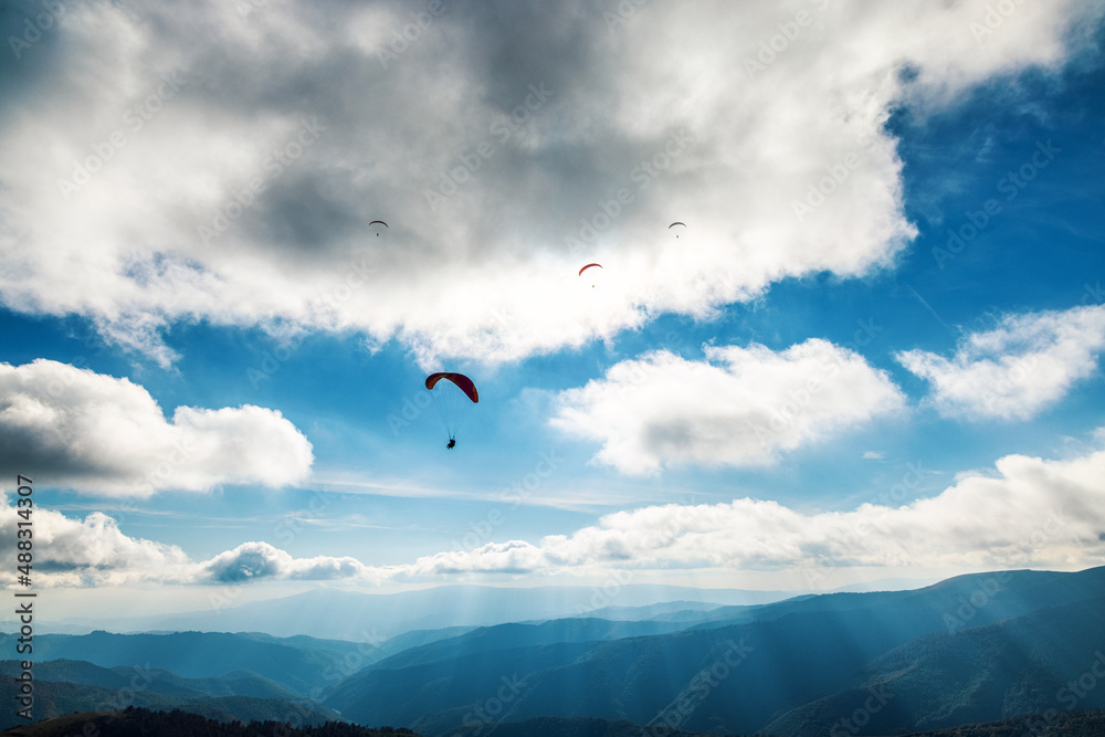Paragliding in highland against giant forestry mountains