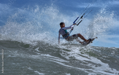 Vietnamese kite surfer jumps with kiteboard in transition