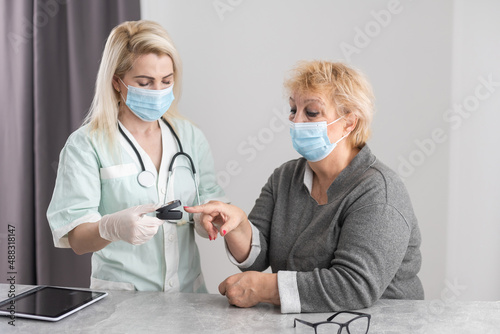 doctor talk with old female patient about disease symptom, doctor use fingertip pulse oximeter with old patient, elderly health check up and health screening, medical technology