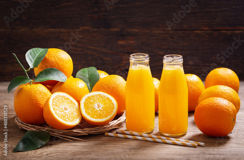 bottles of orange juice with fresh fruits