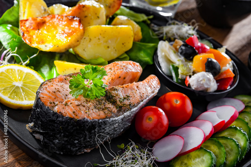 Fried salmon with potatoes and vegetable salads