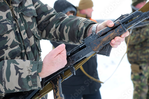 Officer instructor checking Kalashnikov rifle before training in shooting on a military range