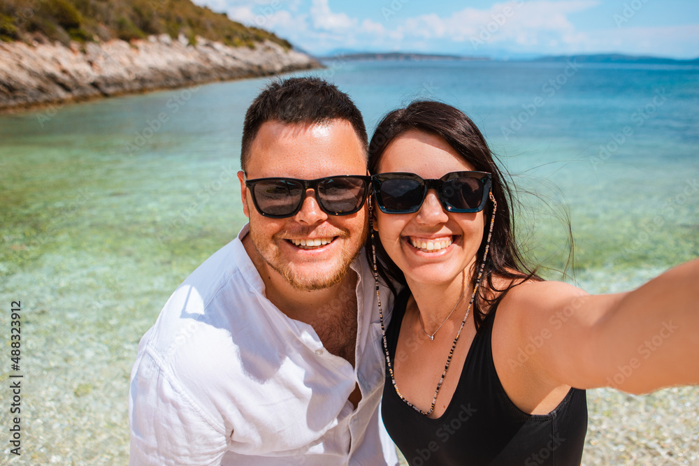 Obraz premium couple taking selfie at sunny day at sea beach