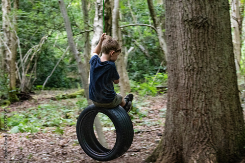 Boy on tree swing in forest