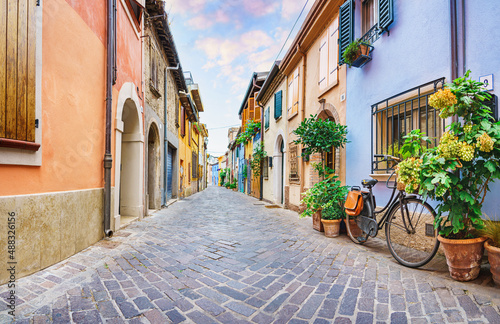 Fototapeta Naklejka Na Ścianę i Meble -  Narrow street of the village of fishermen San Guiliano with colorful houses and a bicycle in early morning in Rimini, Italy