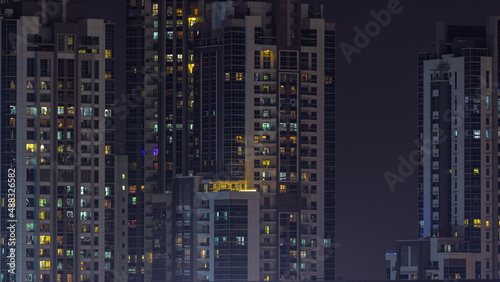 Skyscrapers with glowing windows night timelapse.