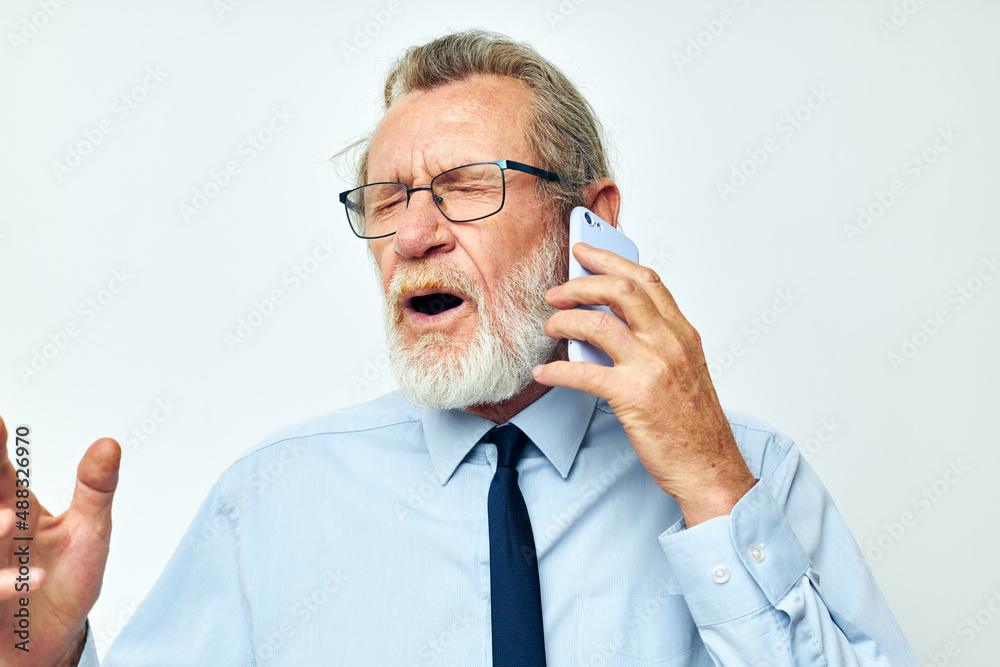 old man in a shirt with a tie talking on the phone cropped view