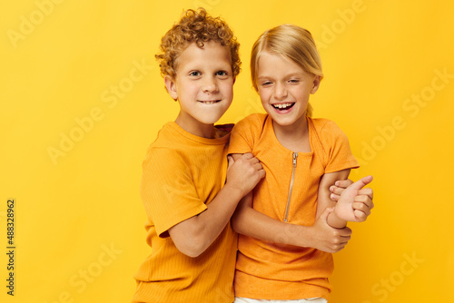 Small children in yellow t-shirts standing side by side childhood emotions isolated background unaltered