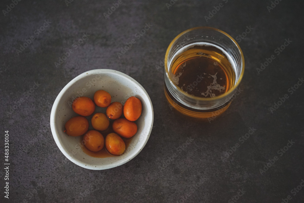 Image of a cold beer along with some olives Image of a cold beer along with some olives