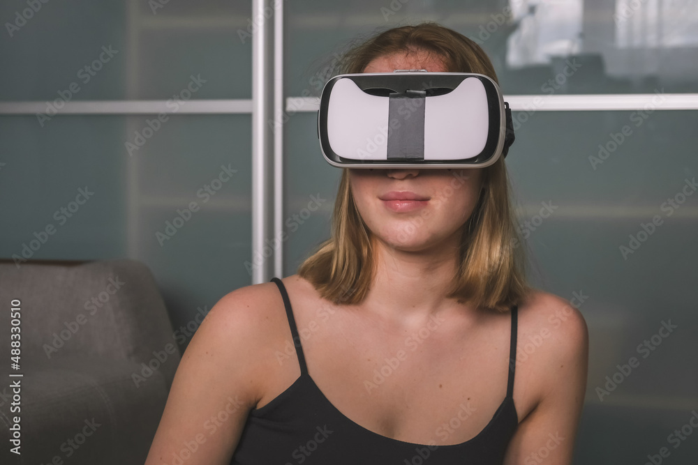 VR relax.European girl using virtual reality to relax and de-stress at home. Girl wearing virtual reality vr glasses relaxes in a virtual environment wellness, mental health immersive reality