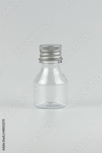 transparent glass small bottle isolated for your text and design. unbranded transparent glass small bottle isolated vertical template copy space