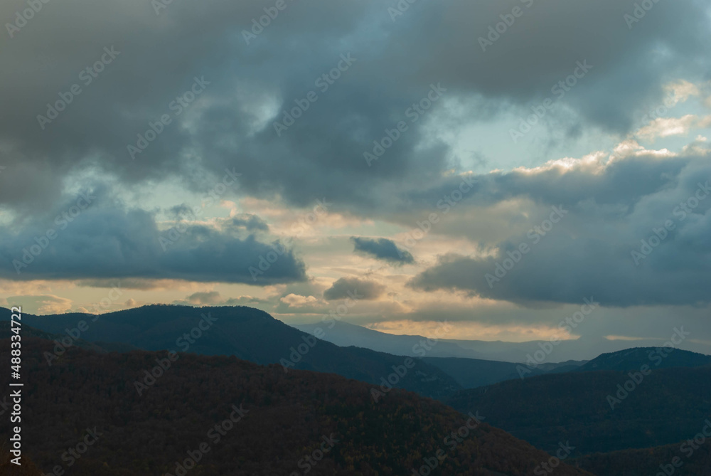 Mountainous landscape with a cloudy sunset sky