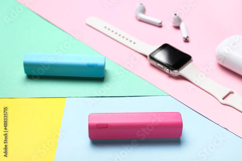 Modern power banks on color background, closeup