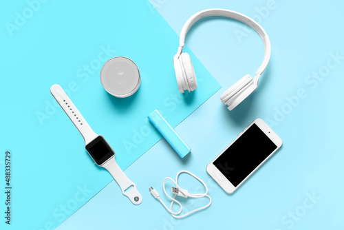 Modern gadgets with power bank on blue background photo