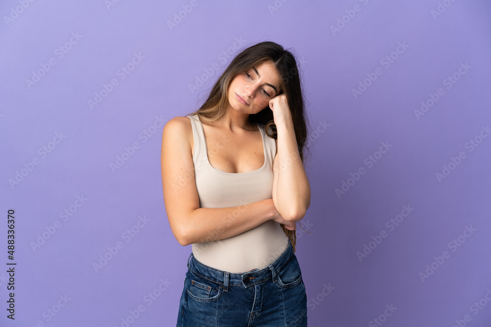 Young caucasian woman isolated on purple background with tired and bored expression Young caucasian woman isolated on purple background with tired and bored expression