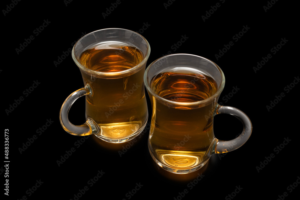 A turkish glass of tea on black background. A turkish glass of tea on black background.
