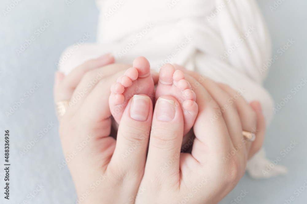 little baby feet holding hands close up 