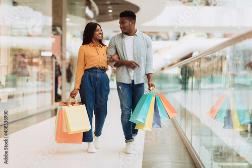 Canvas-taulu Fulll body length of black couple walking with shopping bags
