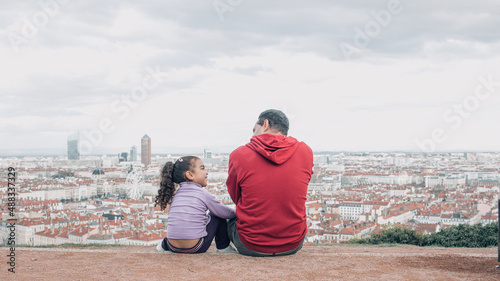 father with his daughter in lyon france on holiday looking at city from above