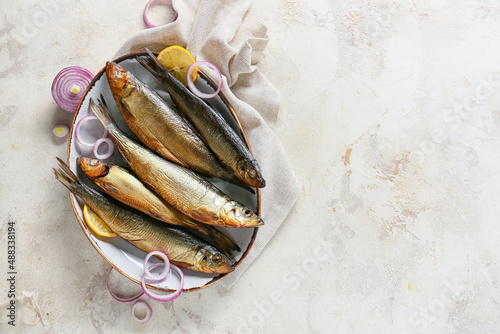 Obraz na płótnie Plate with smoked herring fishes on light background